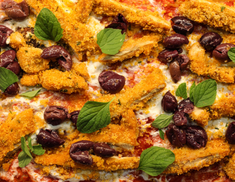 Palermitana, con la sovracoscia di pollo panata con pecorino, pangrattato, prezzemolo e paprika cotta al forno, completata da stracciata e olive di Gaeta